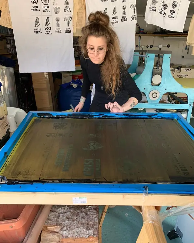Il telaio serigrafico sul banco, con la racla