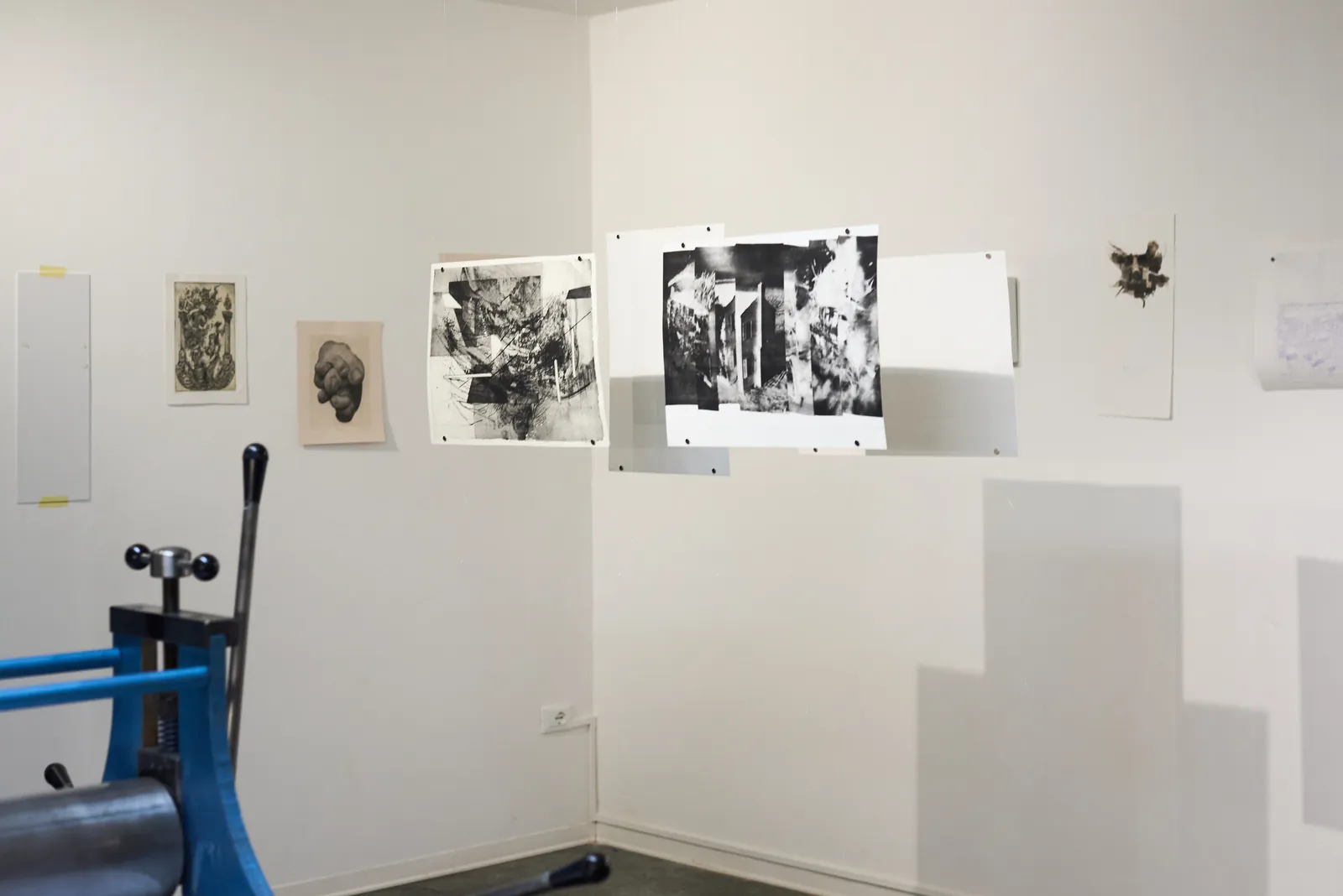 Le opere di «Tracce» alle pareti, accanto al torchio