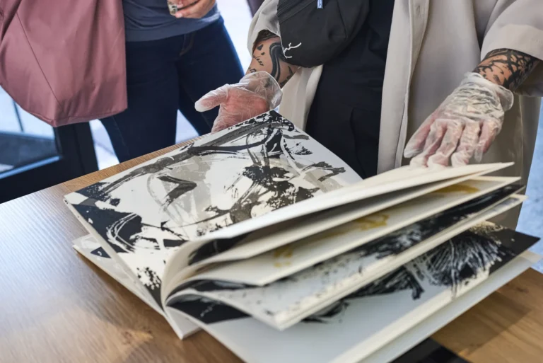 Il libro d'artista di Enrico Bani sfogliato con i guanti bianchi