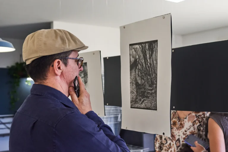 Un visitatore davanti all'opera di Sofia Berzoini, sospesa in sala